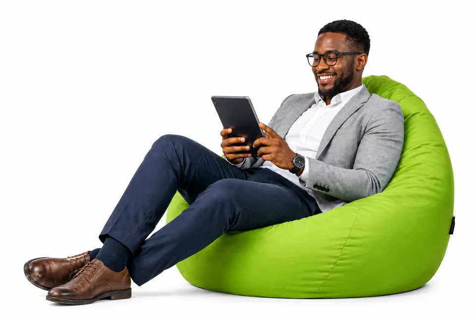 A Kenyan professional seated comfortably while reviewing information on a tablet.